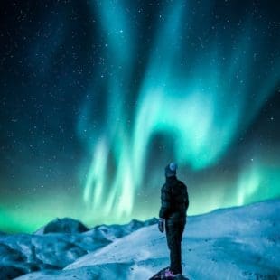 man standing on a rock near snow covered land, ilustrasi cerita fiksi