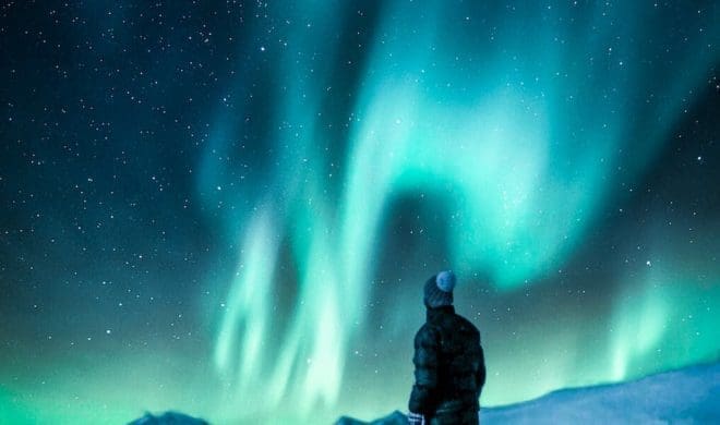 man standing on a rock near snow covered land, ilustrasi cerita fiksi