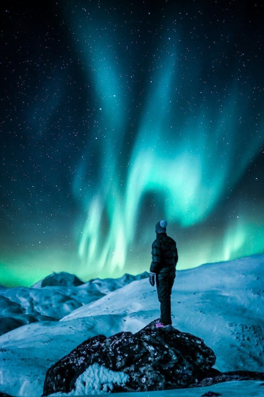 man standing on a rock near snow covered land, ilustrasi cerita fiksi