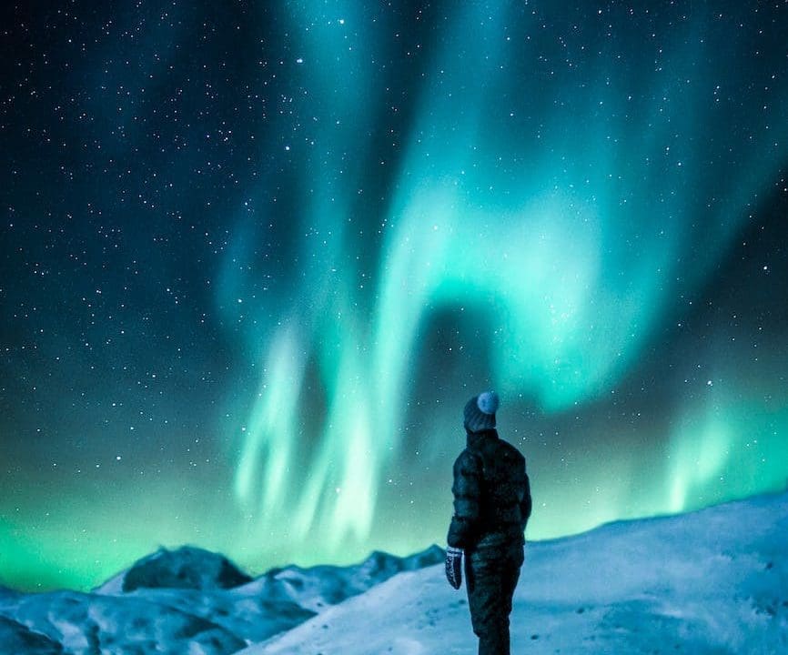 man standing on a rock near snow covered land, ilustrasi cerita fiksi